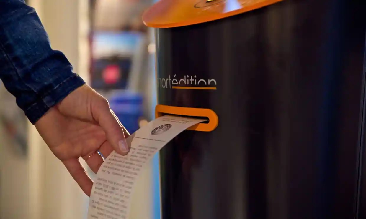 image from In 2019, London’s Canary Wharf introduced vending machines that print out random short stories of a selected genre on receipt-like scrolls. The machines can dispense one, three and five-minute stories free to passersby at the touch of a button.