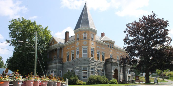 image from The Haskell Free Library and Opera House resides on the Canada–USA border. You can walk in the library from Stanstead, Quebec, Canada and walk out into Derby Line, Vermont, USA.